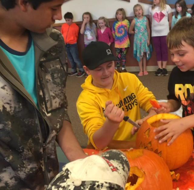 
Sophomore Logan Mehling (center), along with sophomore Joel Perez work with a Southside second-grader during FFA’s pumpkin-carving activity on Oct. 18.