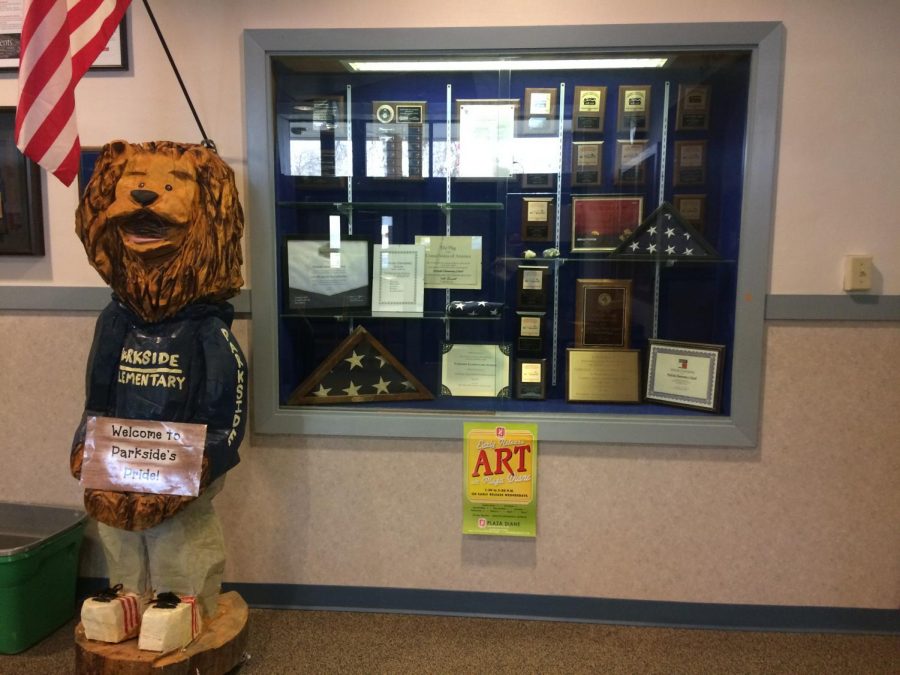 Parkside+Elementary+proudly+displays+awards+and+achievements+beside+a+carved+wooden+lion%2C+which+represents+their+school+mascot.