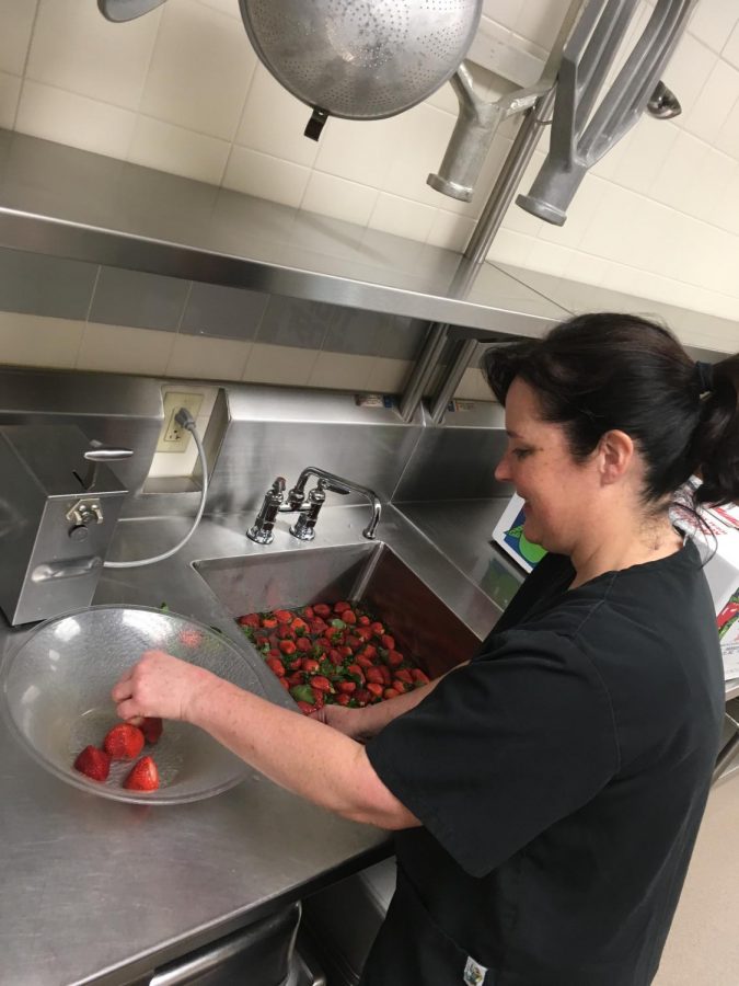 Mrs. Argento cuts up strawberries in preparation for lunch. 