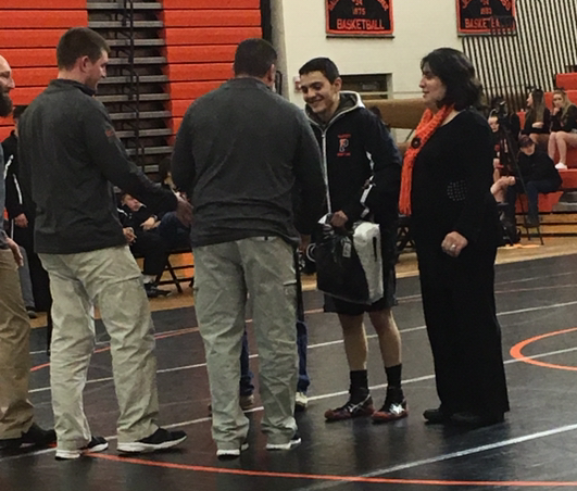 Senior Brian Brazelton (center) is congratulated by coach Nick Fulton (far left) and Nate Urbach and Brians mother Lillian Brazelton on Senior Night. 