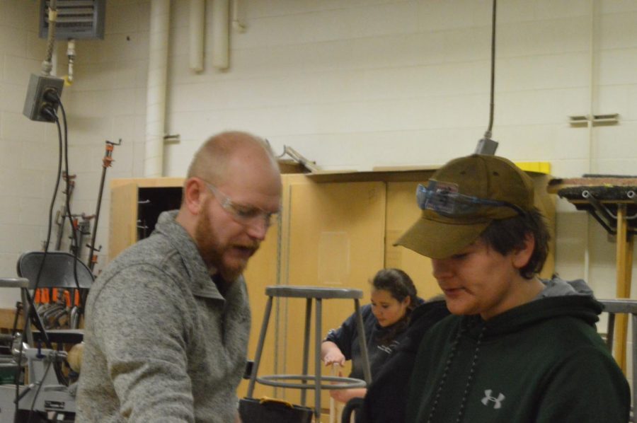 Mr. Ursuy a Skills USA advisor helps a student during Woods class.