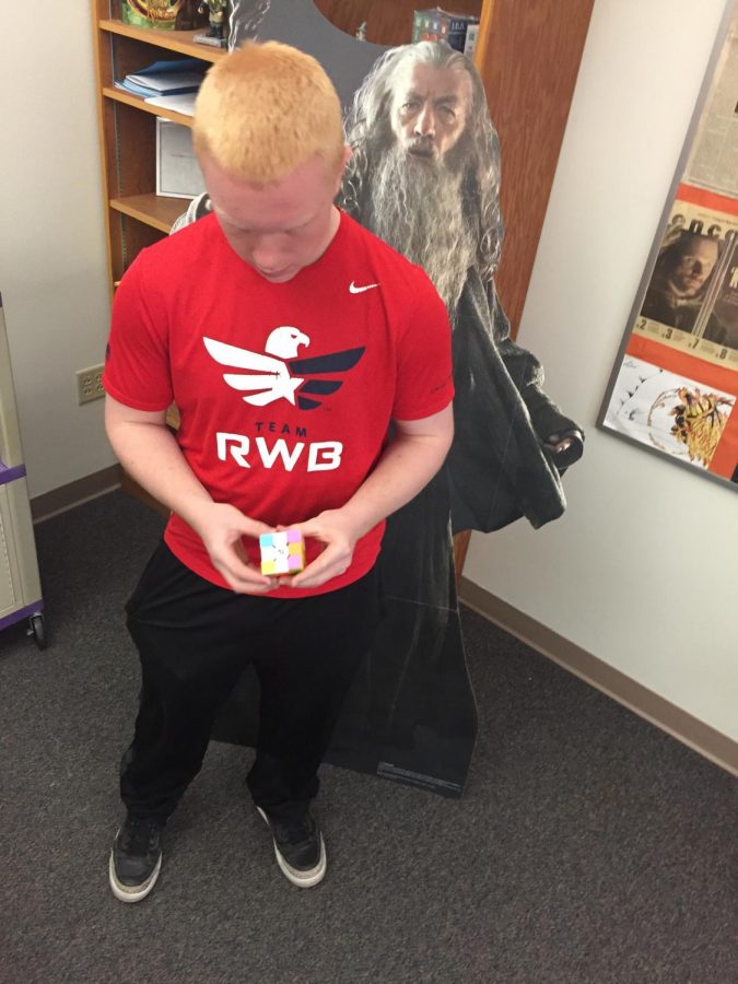 Freshman Geordan Weimer solves a Rubiks Cube, one of several he owns. 