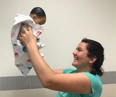 Sophomore Marie Ramier expresses enthusiasm with a baby doll. Babysitting and child care are good ways to earn money in the summer.