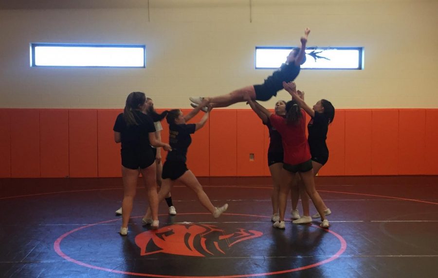 Members of the 2017-18 Cheer Squad lift Addie MIller during practice for the state competition earlier this year.