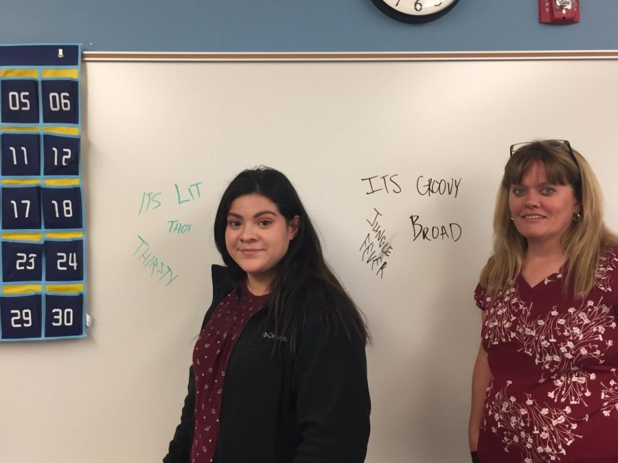 Rachel Gutierrez and Mrs. McArthur stand next to slang of recent and past generations.