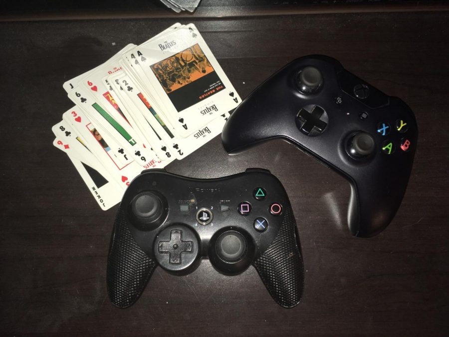 Xbox and PlayStation controllers accompany a deck of cards on junior Lauren DeWitz’s tabletop.