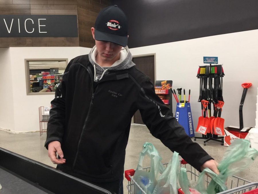 Senior Preston Johnston bags groceries and puts them into the shopper’s cart at Blair’s Supermarket.