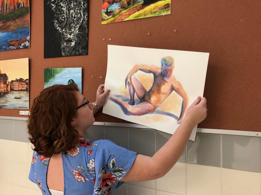 Powell High School junior Randallin Flores removes her abstract nude painting on Dec. 12.