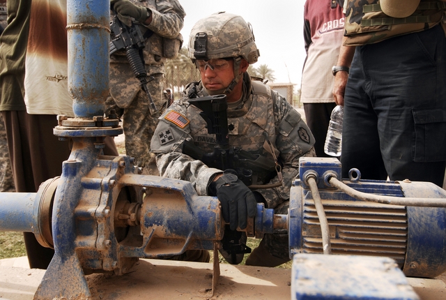 U.S. Army Lt. Col. David Davidson, from 2nd Stryker Brigade Combat Team, 25th Infantry Division, looks at a broken water pump while inspecting a water access point near Al Raoud, Iraq, April 10, 2008.