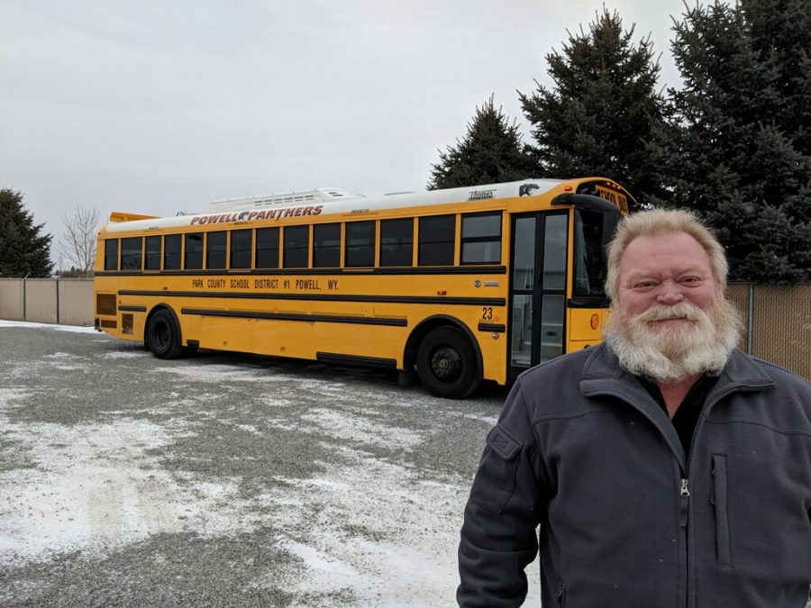 Bus driver Bill Greathouse poses in front of an activity bus.
