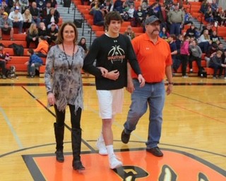 Dalton Woodward is escorted by his parents, Jerry and Angie Woodward, on senior night.
