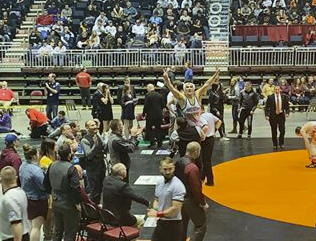 Coach Mr. Nate Urbach lifts Brody Karhu after the state title wrestling match in Casper.