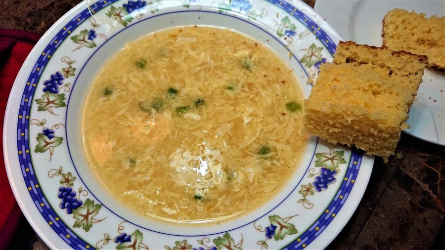 Warm bowl of egg drop soup with a side of cornbread.