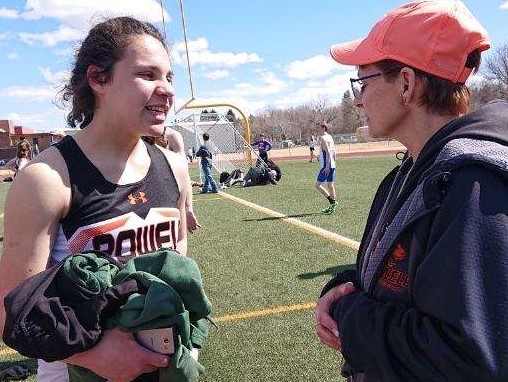 Sophomore Elisa Polson (left) visits with Coach Shelley Heny during the opening meet of the season March 23 in Cody.