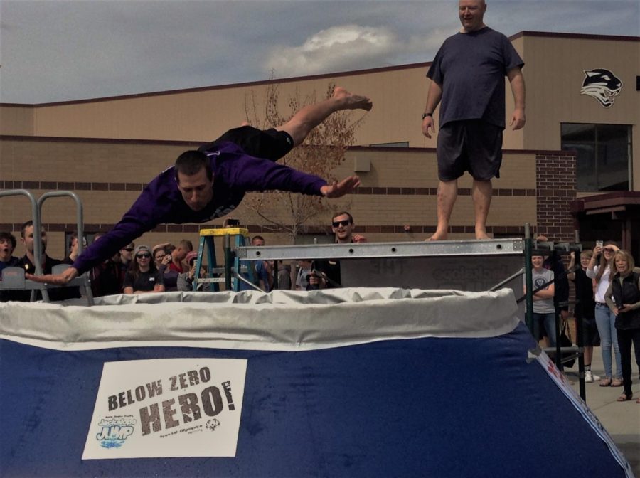 Mr. Preator dives into the pool outside of Powell High School