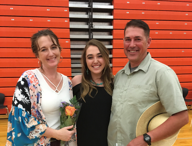 Senior Gracie McLain poses for a picture with her parents at the senior banquet.
