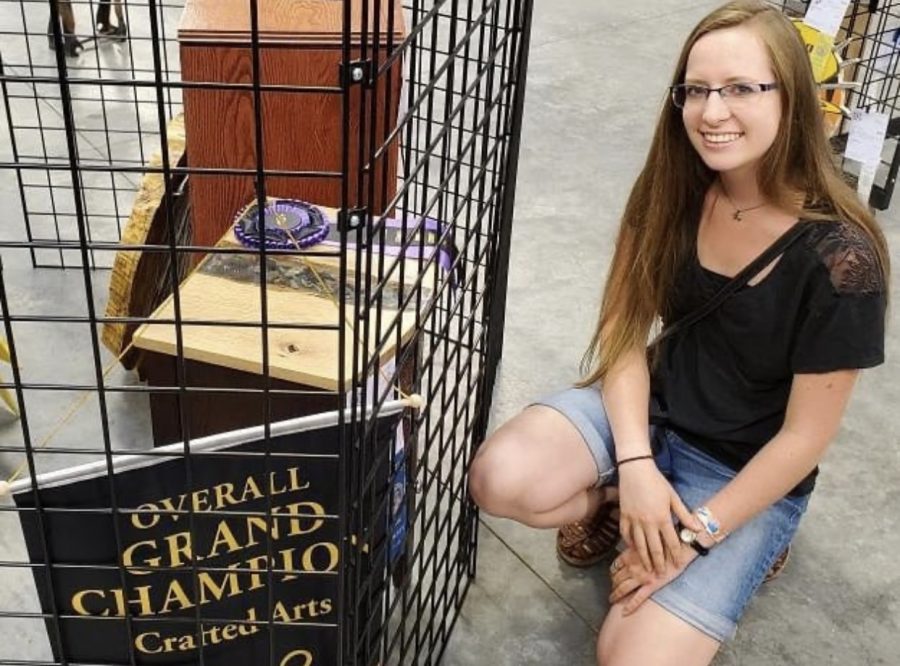 Hannah poses next to her epoxy table, that won Grand Champion at the Park County Fair.
