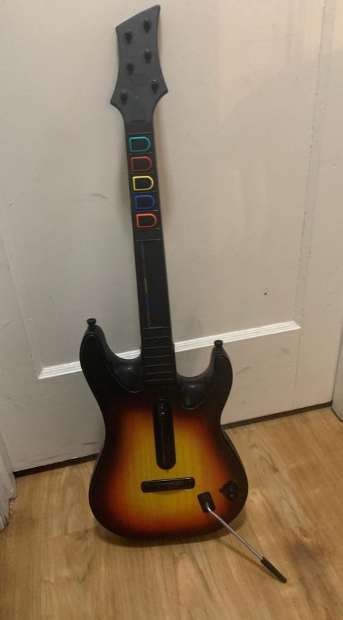  A standard guitar remote for the game series Guitar Hero is displayed.