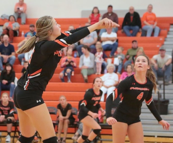 Junior Madi Fields sets the volleyball to teammate Gabby Harshman to score a point.