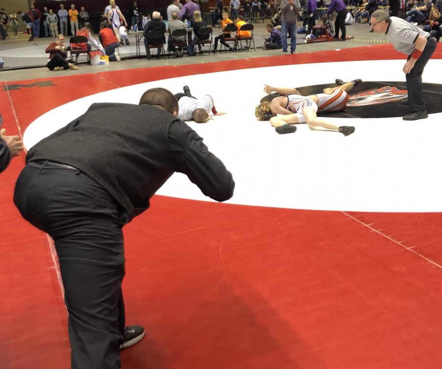 Senior Colt Nicholson goes for the pin in his championship match against Anthony Martinez of Worland as Coach Mr. Nate Urbach yells instructions.