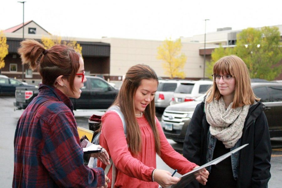 (Left to right) Powell High School sophomore Mads McDowell, senior Rachel Kuntz and senior Natalie Dillivan look at a metal newspaper printing plate.