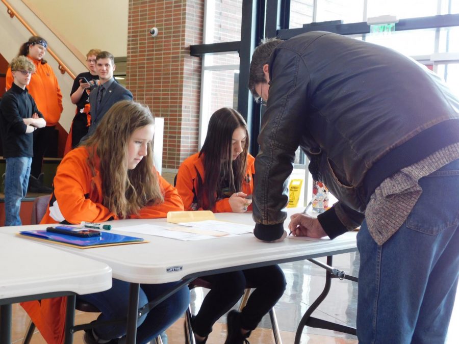 Sophomore Camryn Patton and senior Lauren Dewitz work the check-in table at Powell High Schools speech tournament last year. 