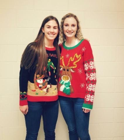 In the PHS locker room, sophomore Megan Jacobsen (left) and senior Hailee Hyde show off their hot Christmas sweaters.