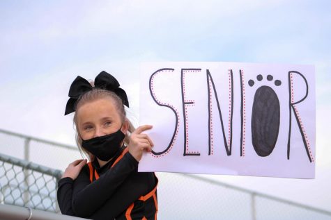 Powell High School junior Morgan Schmidt holds up a sign to clarify where the senior class was to be seated during an assembly earlier in the school year. 