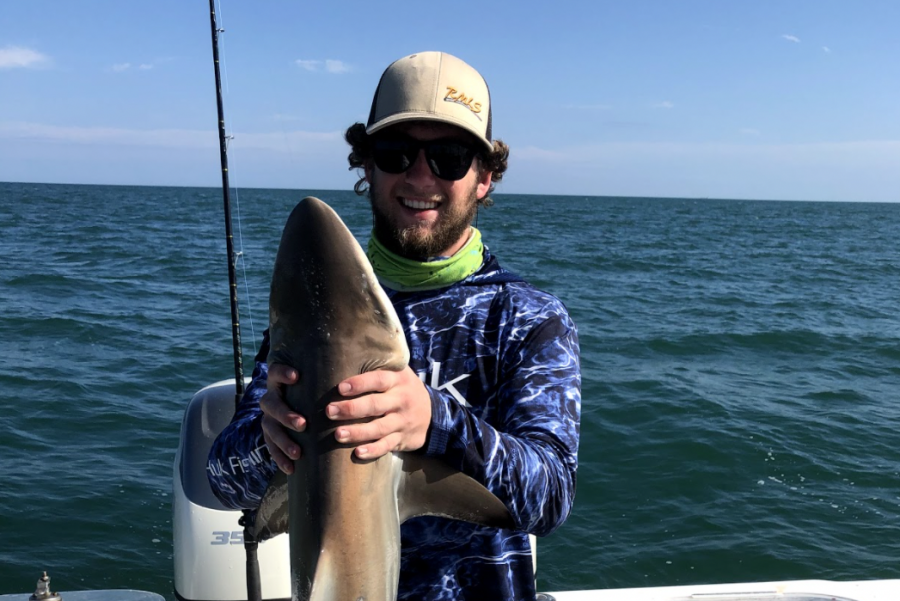 Senior Matthew Hobbs proudly displays the shark he caught while deep sea fishing off the coast of Florida.