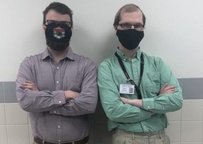 Mr. Drew Gramlich (left) and Mr. Gideon Williams stand in the hallway at Powell High School. 