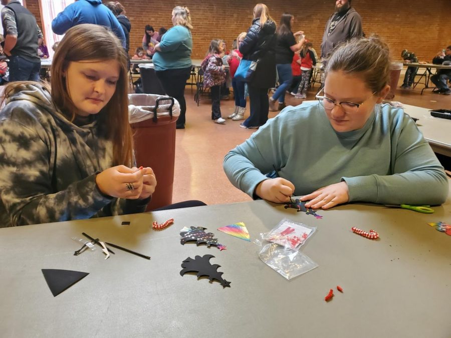 Brianna Evelo (left) and Isabelle Moore (right) decorate ornaments and help young kids decorate theirs at the Downtown Christmas Celebration on Dec 4.