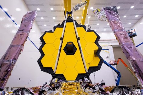 A look at the James Webb telescope from the front. The large hexagonal primary mirror is seen here fully deployed, with the small secondary mirror in front and the sunshield underneath.