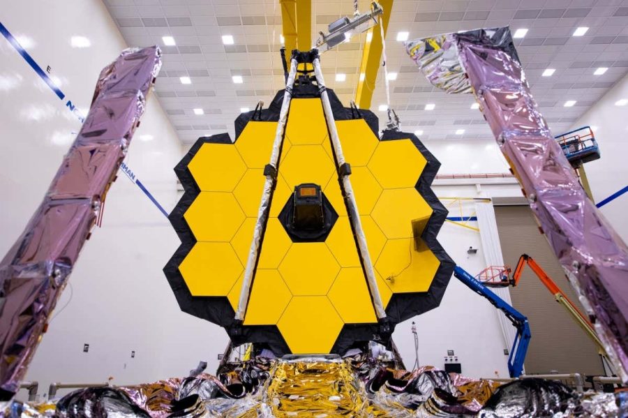 A+look+at+the+James+Webb+telescope+from+the+front.+The+large+hexagonal+primary+mirror+is+seen+here+fully+deployed%2C+with+the+small+secondary+mirror+in+front+and+the+sunshield+underneath.