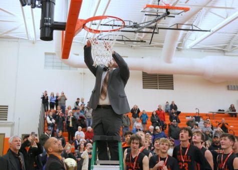 Head Coach Mike Heny cuts down the net after the Panthers claim the 2022 Reigonal title.