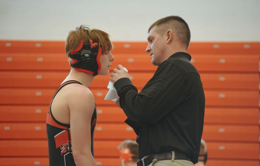 Panther+wrestling+head+coach+Nick+Fulton+assists+junior+Jeremy+Harms+with+a+bloody+nose+after+a+match+on+the+mat.++