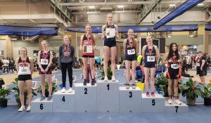 Senior Anna Bartholomew stands at eighth on the podium, cementing her place as the first girl in Powell High School Indoor Track history to do so in her event, the 800 Meter Dash.  
