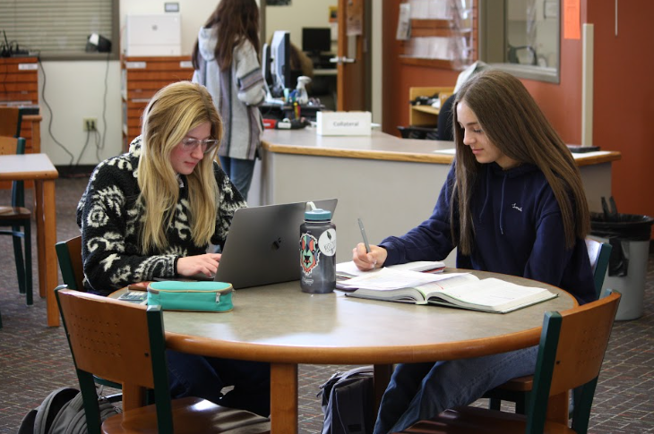 Seniors Chase Anderson and Anna Bartholomew work on homework in the library. The Powell High School library is where many students go to work on college classes rather than check out and read books.