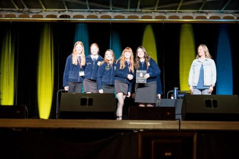 Powell-Shoshone FFA members join 2022-2023 State President Sarah Turner on stage after being recognized as 3rd high in Agronomy.