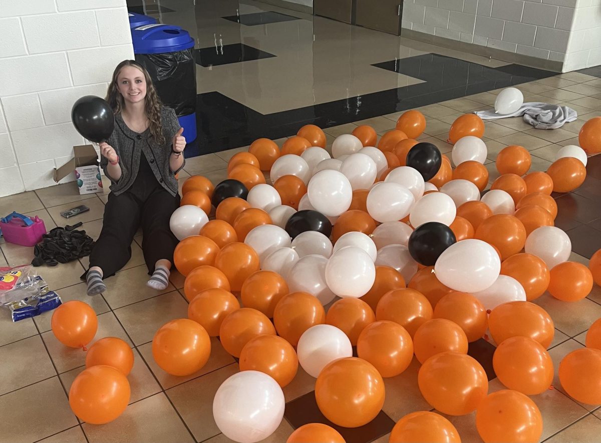 Student Council Junior Class Representative Caitlin Belmont works diligently on the balloon decorations the day before Homecoming Week.