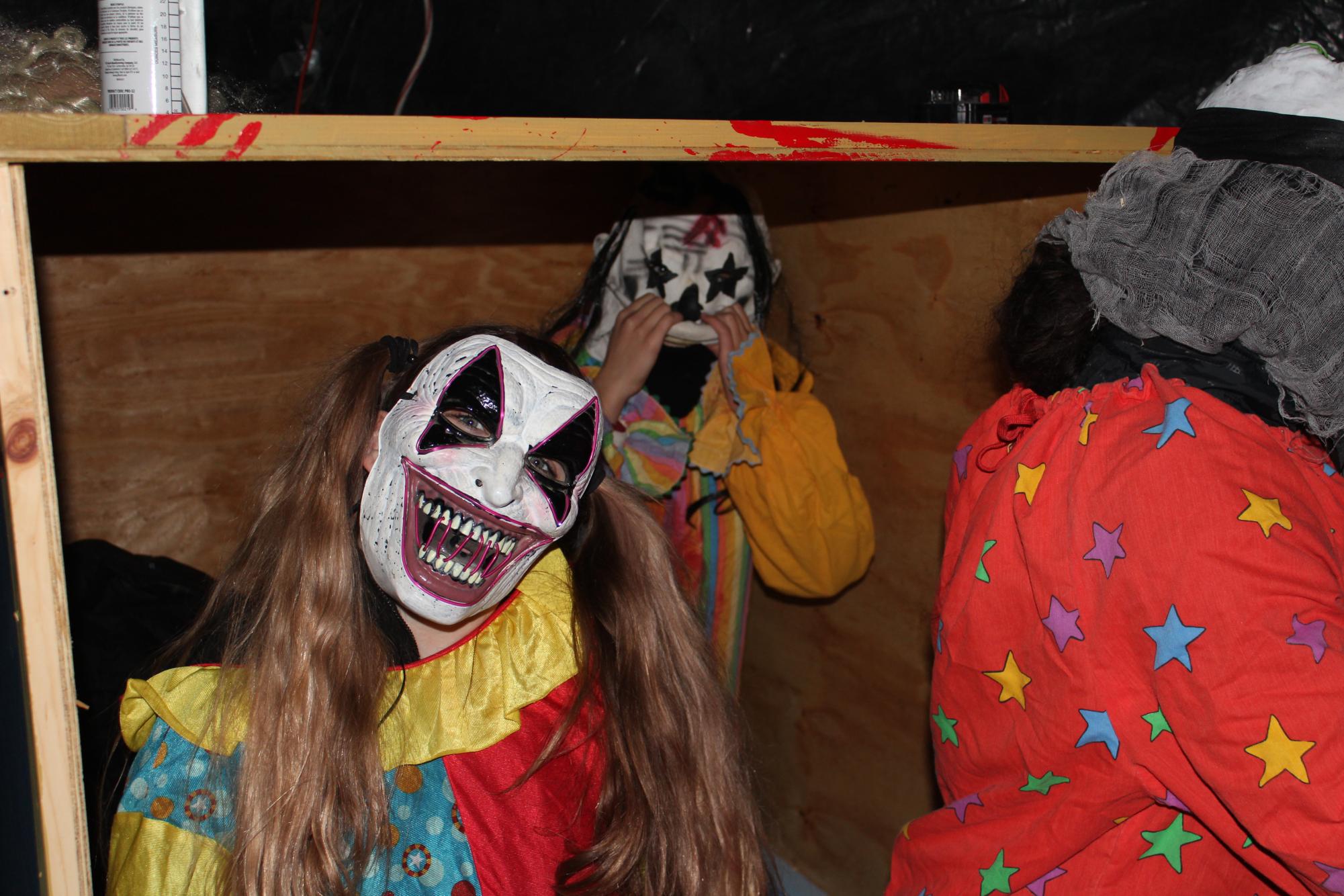 Some of the dedicated drama club members, dressed as clowns, attempt to scare passerby at the haunted house. 