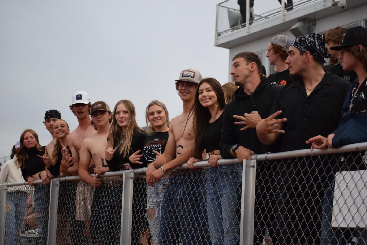 Student section of October Blackout is all smiles and posing for the camera, capturing the high school night life in Powell.