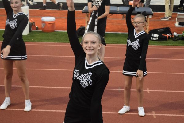 Sophomore Luci Dees gazes up, while participating in the cheer moves.