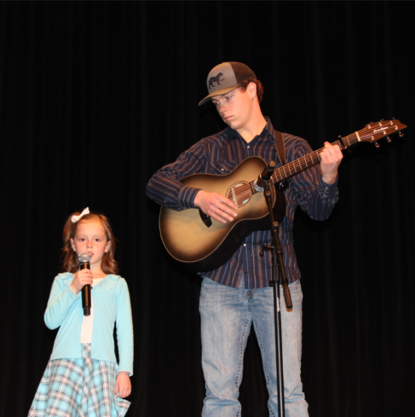 Senior Adam Williams accompaniments his younger sister Emma with his guitar. 