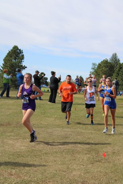 Freshman Jordyn Nelson runs at the Powell golf course for a XC event.