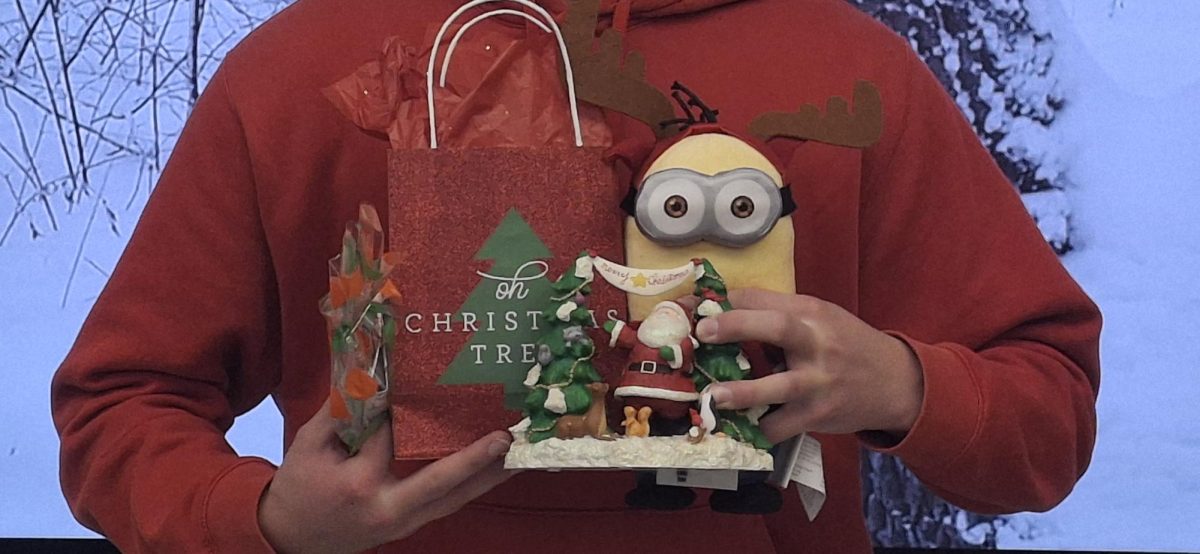 PHS student holds various Secret Santa and white elephant gifts from previous parties.