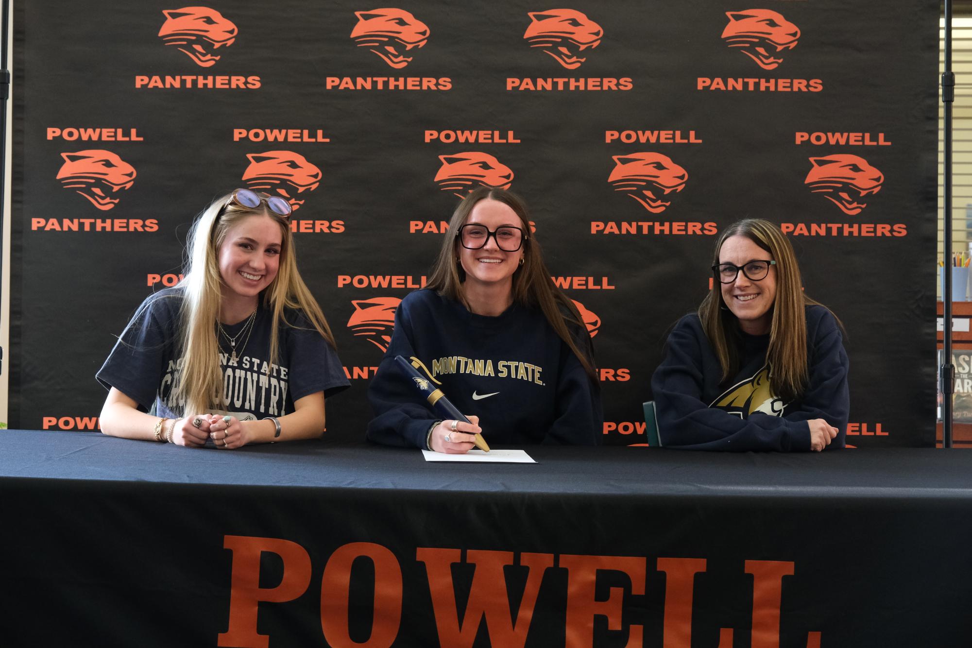 Kinley Cooley is surrounded by her younger sister Karee and mother Kodi as she signs with MSU.