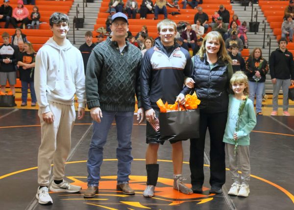 Senior Cody Seifert smiles with his family before the dual against Thermopolis.