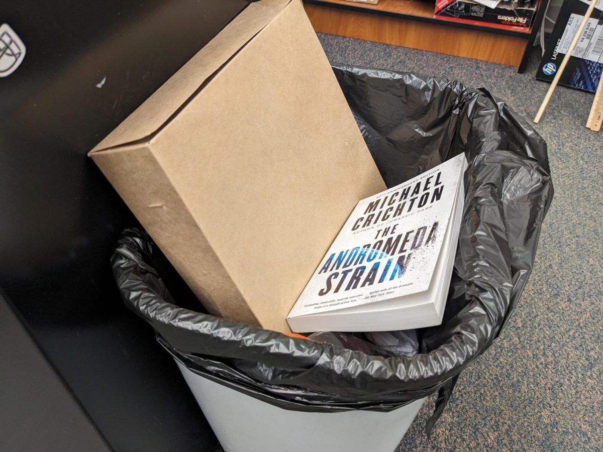 Micheal Crichton’s “The Andromeda Strain” sits at the bottom of a trash bin at PHS.