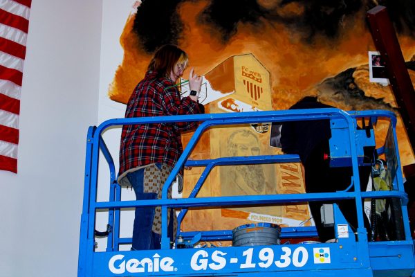 Janicia Ramirez and Geo Dilworth are captured painting the mural in the commons, laughing and having fun while doing so.