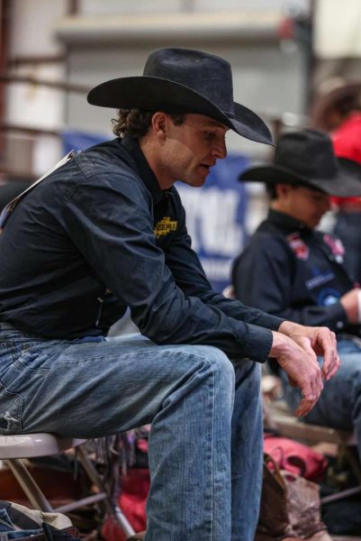 Powell High School graduate and bronc rider Brody Wells watches others compete.